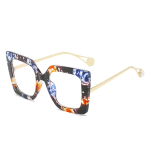 Oversized square eyeglasses with colorful patterned frame and pearl-tipped gold metal temples