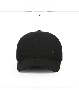 Close-up of black wool baseball cap with woven texture and shield-shaped metal logo