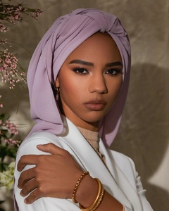 Detail of light purple pearl chiffon hijab worn by a model with gold jewelry accessories