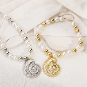 Macro detail of mixed pearl necklaces featuring shell pendants in gold and silver finishes