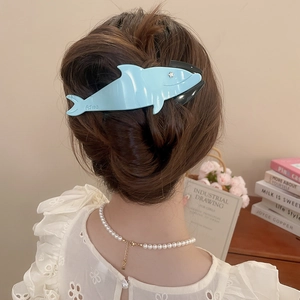 Detail showing gradient shark hair claw clip styled on a woman's back hairstyle