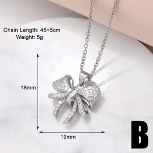 Macro detail of silver bow pendant with cubic zirconia inlay including size specifications