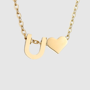 Détail du collier en acier inoxydable doré avec pendentif lettre U et petit cœur