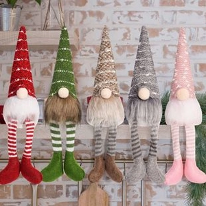Close-up of five colorful Christmas gnomes with striped long legs in a row