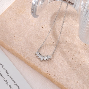 Silver marquise-cut zircon flower petal pendant necklace on a beige stone surface