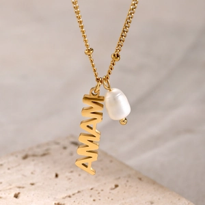Macro shot of 18k gold plated MAMA letter pendant with a white freshwater pearl