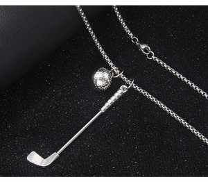 Close-up of silver golf club and ball pendant necklace with a fine box chain detail