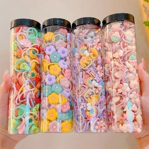 Close-up of colorful cartoon hair ties for girls in a clear plastic storage jar