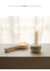 Detail of modern white ceramic doughnut candle holder and tray set on a dining table
