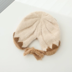 Detaillierte Textur der beige-braunen Plüsch-Strickmütze mit weichen Bändern aus Kunstpelz