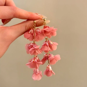 Close-up of elegant pink fabric lily of the valley tassel earrings with layered petals.