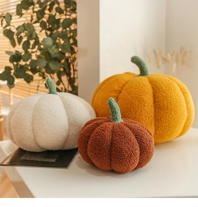 Three multi-colored plush pumpkin pillows in orange, white and brown for home decor