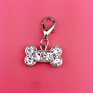 Shiny bone-shaped pet collar pendant with rhinestones and lobster clasp on pink background
