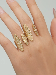 Detailed view of gold butterfly ring with zircon micro-pave on model's hand