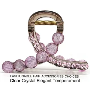 Detail of transparent brown hair claw clip with purple beads and pink rhinestones