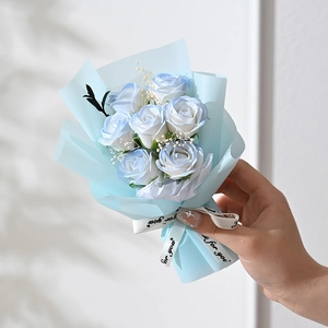 Close-up of 7-piece blue gradient soap rose bouquet with baby's breath and ribbon