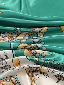 Macro shot of satin silk scarf featuring elegant lily of the valley floral prints