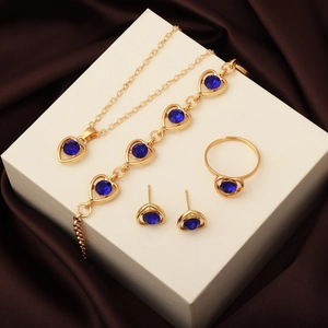 Detail of jewelry set with deep blue heart crystals on a golden finish display