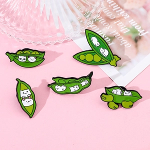 Set of five cute pea pod cat enamel pins displayed on a soft pink background