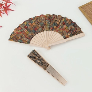 Detail of Portuguese cork folding fan with vibrant geometric floral patterns on fabric