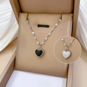 Detailed view of heart pendants with black and white zircon pavé on silver chain
