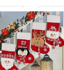 Set of four knitted Christmas stockings featuring Santa and reindeer on white stairs
