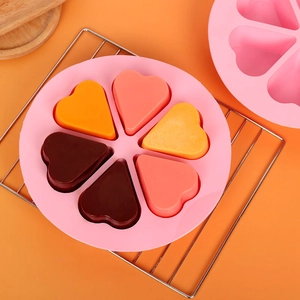 Roze siliconen bakvorm met 6 hartvormige holtes op een koelrek voor DIY bakken