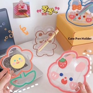 Close-up of cute cartoon acrylic pen holders with colorful edges for desk storage
