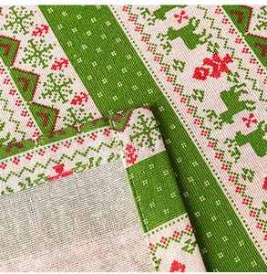 Close-up of woven linen texture with Christmas reindeer and snowflake embroidery pattern
