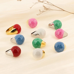 Macro shot of 18k gold enamel ball rings in Morandi colors on silk background