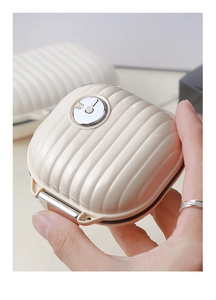 Macro shot of compact cream-colored medicine case with striped suitcase design texture