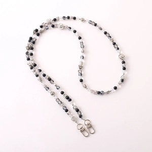 Detailed view of handmade beaded phone strap with black beads and silver metal rose charms