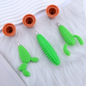 Three creative cactus-shaped pens with orange flower pot bases on a white plush surface