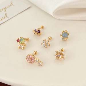 Macro shot of 6-piece gold earring set featuring bear and flower motifs with cubic zirconia