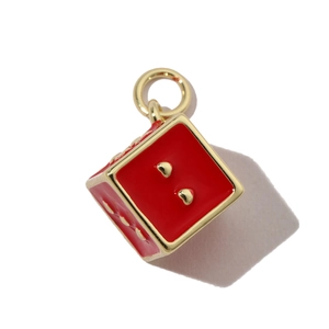 Macro shot of red heart dice charm with gold dots and polished metal loop