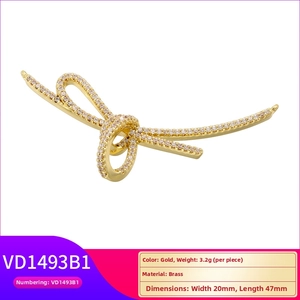 Detail view of gold brass bow pendant with sparkling cubic zirconia measuring 20mm by 47mm
