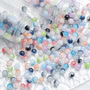 Colorful 10mm ice crackle glass beads scattered on water ripple background for DIY jewelry