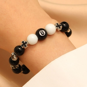 Obsidian beaded bracelet with 8-ball charm and silver cross beads on wrist