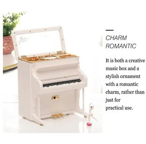 Close-up of white upright piano music box with realistic keys and golden pedal detail