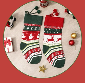 Close-up of knitted Christmas stockings with snowman and reindeer patterns on wood background