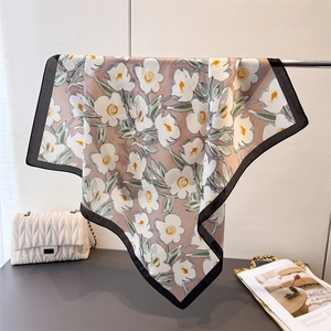 Detail eines Seidenschals mit Blumenmuster in Rosa mit weißen Blumen und schwarzem Rand
