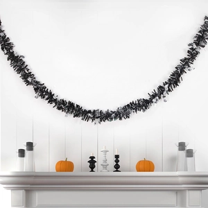 Detail of 2m black Halloween tinsel garland with pumpkins on a white fireplace