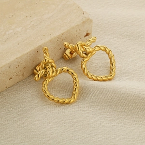 Boucles d'oreilles nœuds torsadés dorées en acier inoxydable sur support en pierre