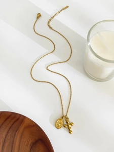 Detailed close-up of gold titanium steel double pendant necklace with Mary and cross icons
