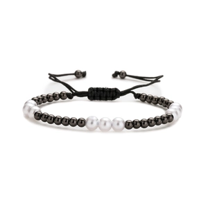 Adjustable black and white bead bracelet with woven cord and polished metal accents