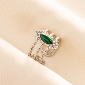 Detail of silver stainless steel ring featuring green oval stone and braided texture band