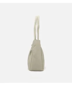 Side view detail of off-white canvas tote bag showing base thickness and soft fabric folds
