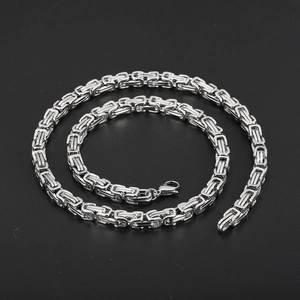 Macro shot of silver Byzantine titan steel chain with lobster clasp on dark background