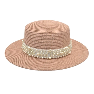 Détail d'un chapeau de paille rose avec perles élégantes et tissage de haute qualité
