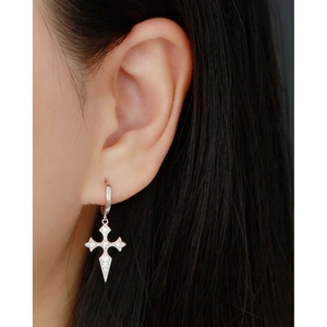 Close-up of S925 sterling silver hoop earring with diamond-studded cross pendant on ear
